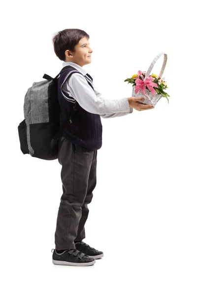 Schüler in Uniform mit einem Korb voller Blumen — Stockfoto