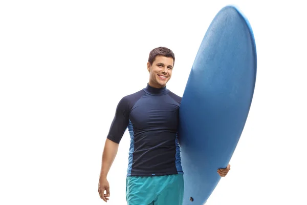 Mladý muž s surferem držící surfu a usměvavý fotoaparát — Stock fotografie
