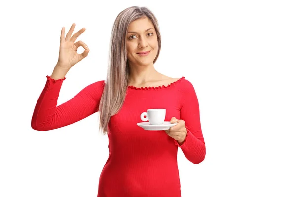 Pretty young woman with a cup of coffee gesturing perfect sign — Stock Photo, Image