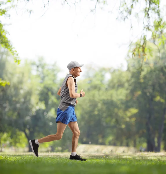 Elderly man running outdoors — Stock Photo, Image