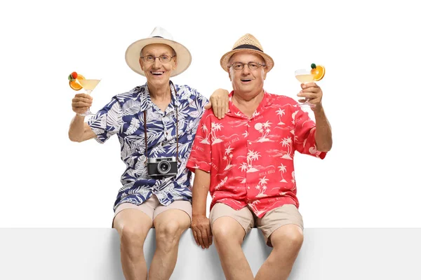 Senior manliga vänner med cocktails sitter på en panel — Stockfoto