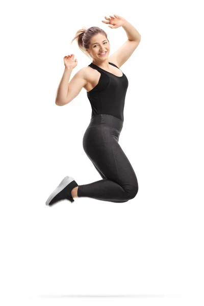 Young happy woman in sportswear jumping and smiling — Stock Photo, Image