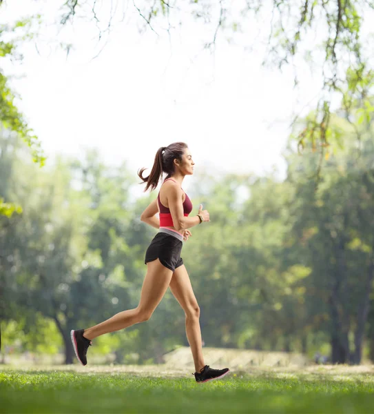 Junge Frau joggt in einem Park — Stockfoto