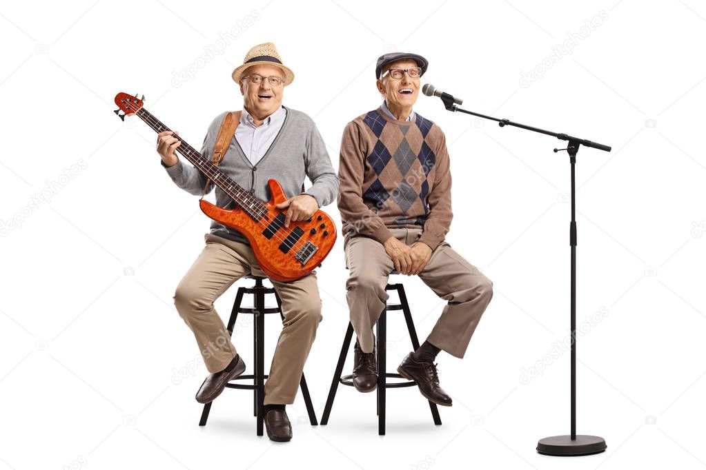 Two senior men sitting with an electric guitar and a microphone