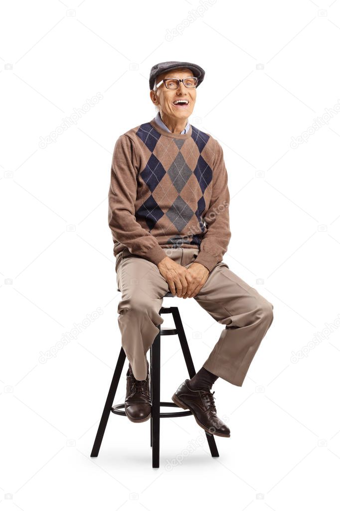 Cheerful elderly gentleman smiling and sitting on a high chair 