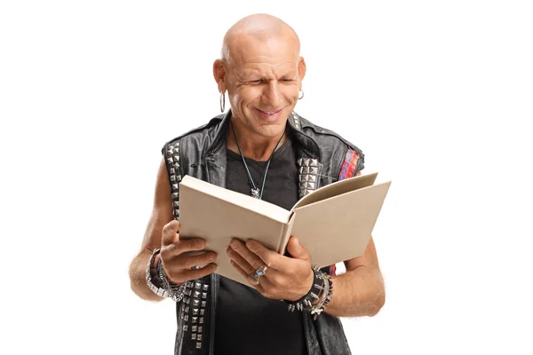 Punker em colete de couro lendo um livro — Fotografia de Stock