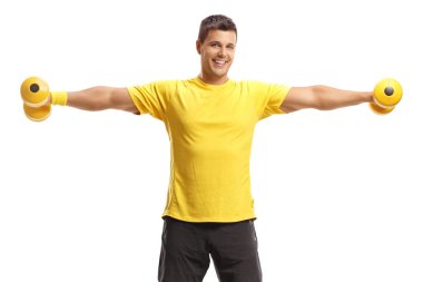 Dambıllarla egzersiz yapan genç adam.