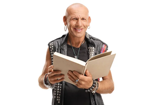 Punker in lederen vest met een boek en glimlach naar de camera — Stockfoto
