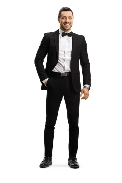Eleganter junger Mann in Anzug und Fliege posiert mit der Hand in der Tasche — Stockfoto