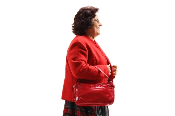 Äldre dam med en röd kappa Walking — Stockfoto