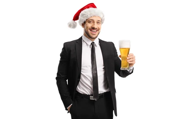 İş adamı Noel Baba şapkası takıyor ve elinde bir bardak... — Stok fotoğraf