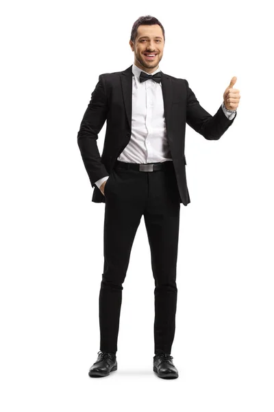 Young elegant man in a suit and bow showing thumbs up — ストック写真