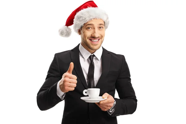 Elinde bir fincan espresso tutan Noel Baba şapkalı bir iş adamı. — Stok fotoğraf