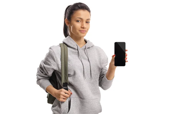 Девушка в толстовке с рюкзаком, показывающая смартфон — стоковое фото