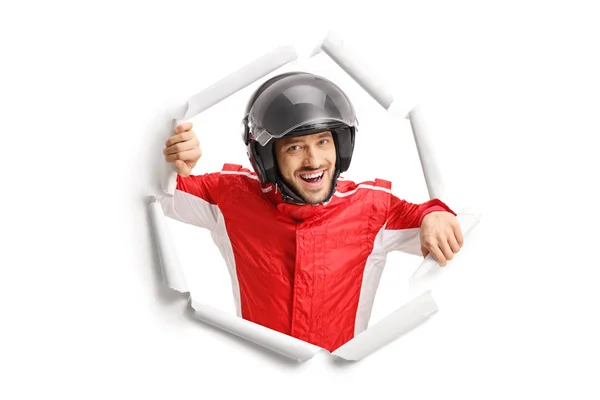 Racer met een helm gluren door een gescheurd papier gat — Stockfoto