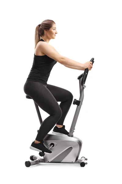 Young woman riding a stationary bike — Stock Photo, Image