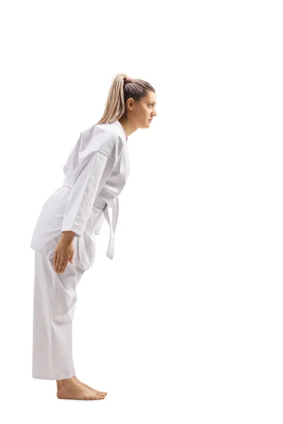 Perfil de cuerpo entero de una mujer en kimono de karate inclinándose — Foto de Stock