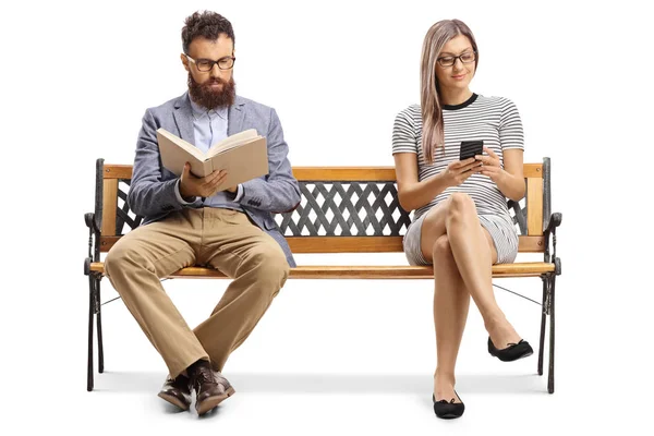 Homme lisant un livre et femme assise sur un banc et tapant sur un — Photo