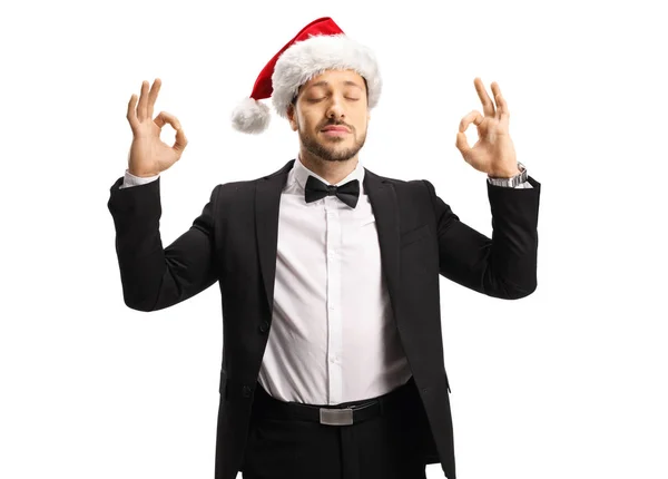 Uomo in giacca e cravatta con cappello da Babbo Natale e meditati — Foto Stock