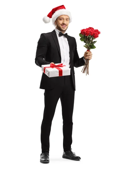 Young man in a suit and bow tie wearing a santa claus hat and ho — Stock Photo, Image