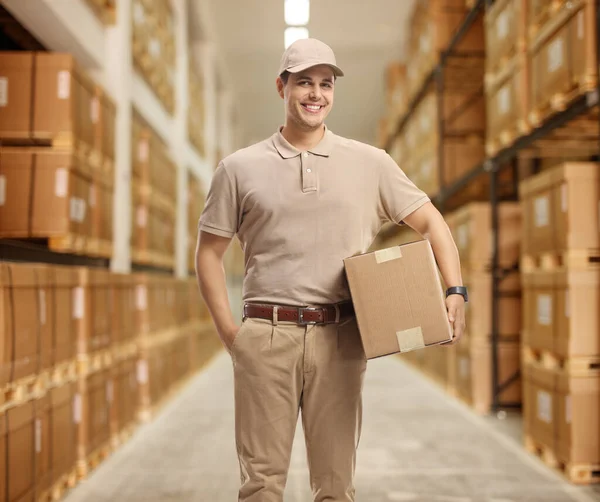 Teslimatçı depoda bir paket tutuyor. — Stok fotoğraf