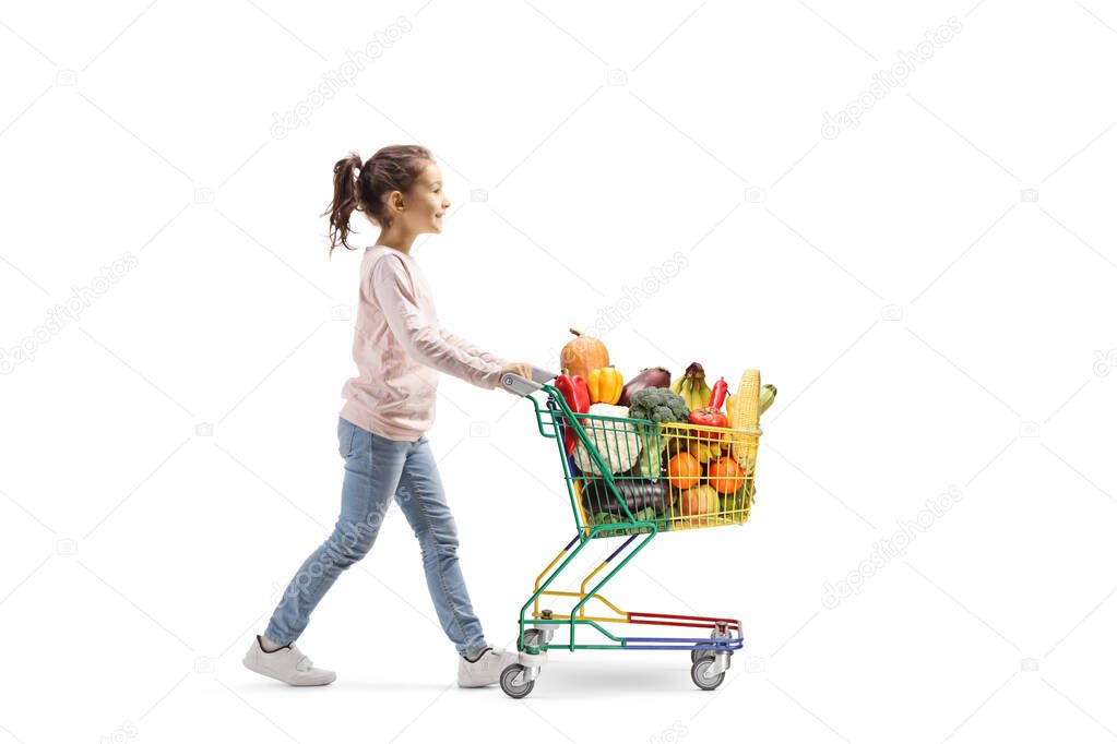 Little girl walking and pushing a shopping cart with fruits and 