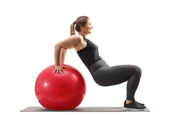 Jovem mulher exercitando sentar-se com uma bola de fitness — Fotografia de Stock