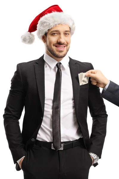 Facet wkłada pieniądze do kieszeni biznesmena z Mikołajem. — Zdjęcie stockowe