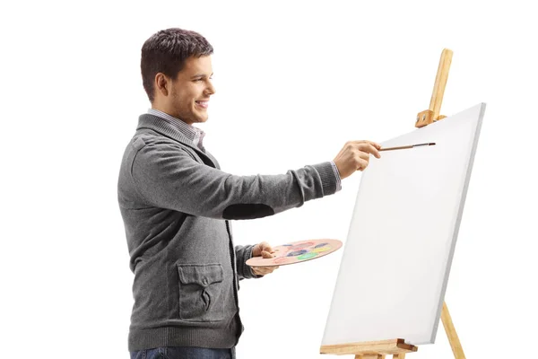 Mladý muž maluje na plátně — Stock fotografie
