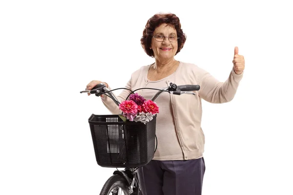 Пожилая женщина с велосипедом делает большой палец вверх знак — стоковое фото