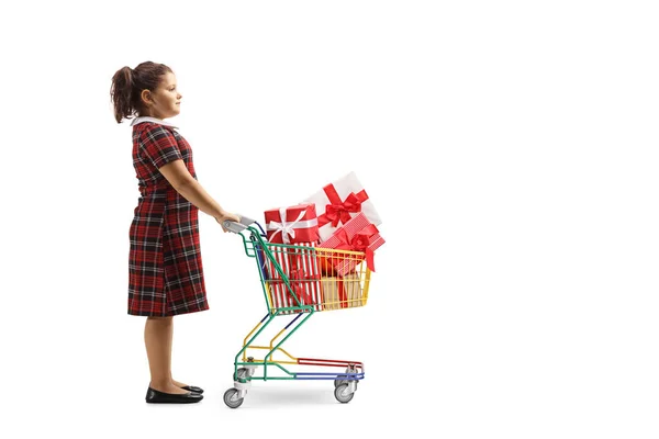 Paketlenmiş hediyelerle dolu küçük bir alışveriş arabasıyla duran kız. — Stok fotoğraf