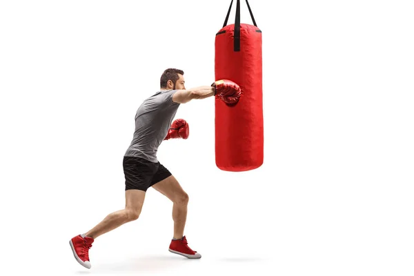 Caja de entrenamiento de hombre muscular joven con un saco de boxeo — Foto de Stock