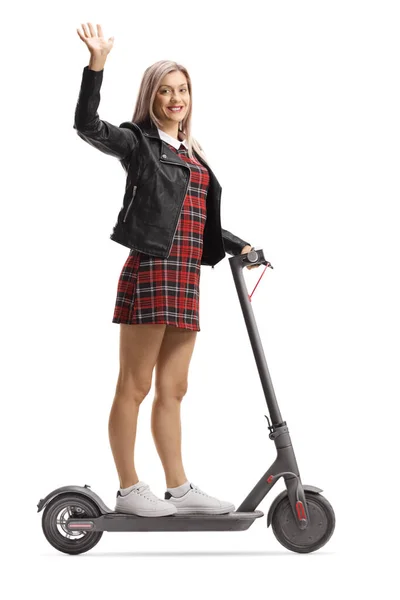 Trendy young female on an electric scooter waving with one hand — Stock Photo, Image