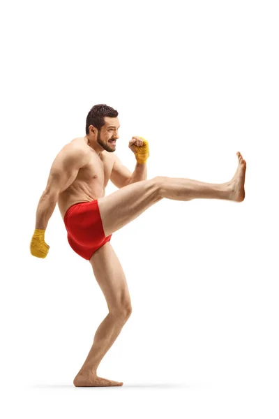 Fit man oefenen kickboksen en duwen met zijn been — Stockfoto