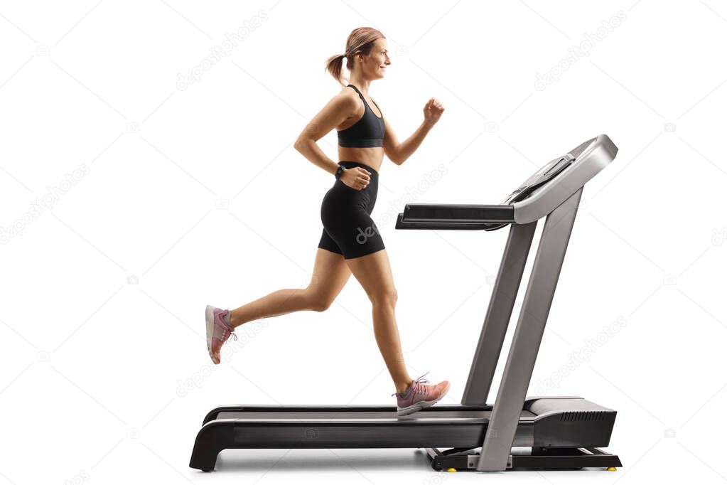 Fit woman running on a treadmill and smiling