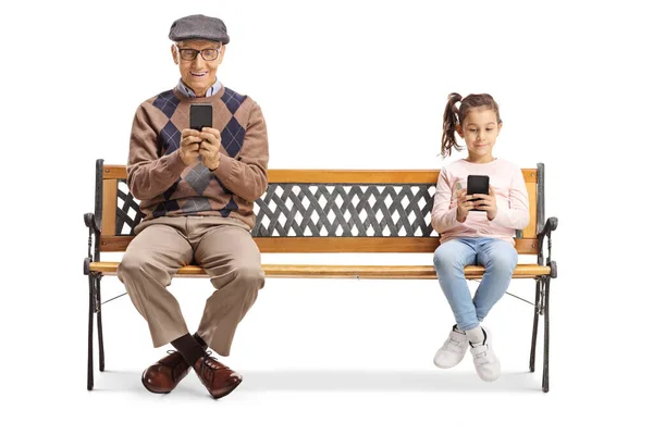 Dědeček a vnučka sedí na lavičce a používají chytré — Stock fotografie