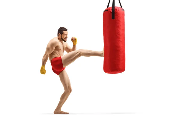 Joven musculoso ejercitando kickboxing y pateando un puñetazo — Foto de Stock