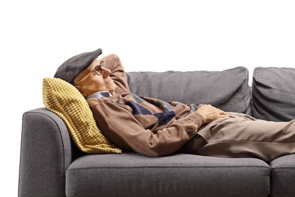 Senior man sover på en soffa — Stockfoto