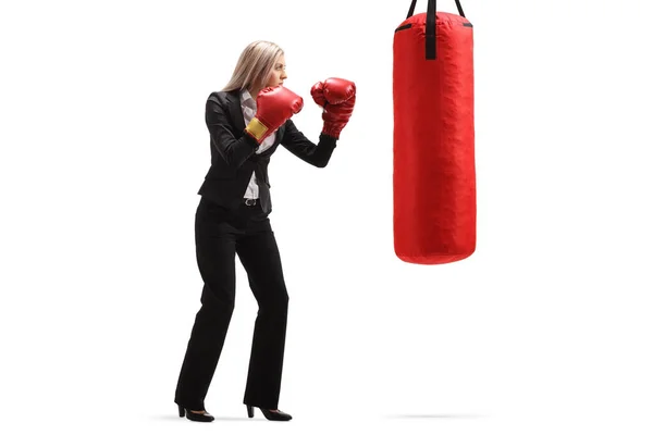 Femme d'affaires avec des gants de boxe rouge s'exerçant avec un poinçon — Photo