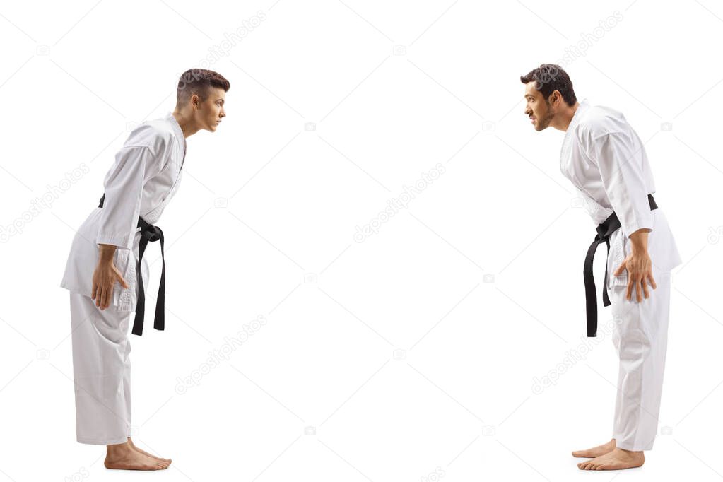 Young men in karate kimonos bowing to eachother 