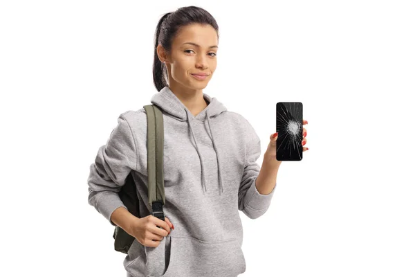 Kvindelig studerende holder en smartphone med en brækket skærm - Stock-foto