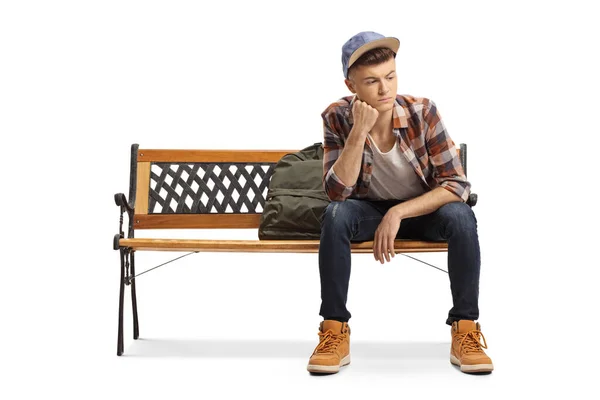 Jovem estudante preocupado sentado em um banco e olhando para longe — Fotografia de Stock