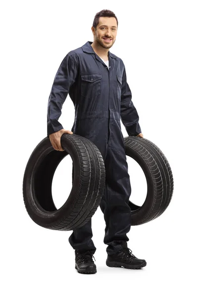 Young male mechanic holding vehicle tires — Zdjęcie stockowe