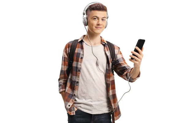 Männlicher Student, der ein Mobiltelefon in der Hand hält und Musik hört — Stockfoto