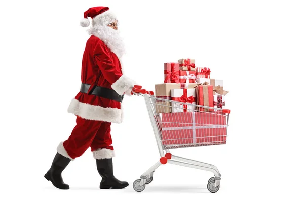 Święty Mikołaj pchający wózek pełen prezentów — Zdjęcie stockowe