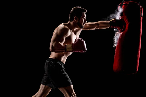 Boxer perfurando um saco com partículas de poeira saindo — Fotografia de Stock