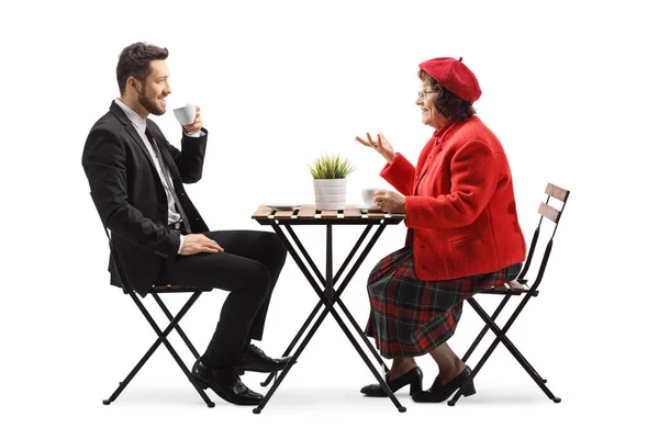 年配の女性とカフェに座って白地に隔離された話をするビジネスマン — ストック写真
