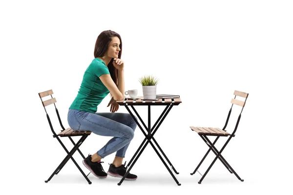 若い女性は木製のテーブルに座って白い背景に隔離された考え — ストック写真