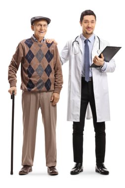 Beyaz arka planda izole edilmiş bastonlu yaşlı bir adamın yanında poz veren genç bir erkek doktorun tam boy portresi.