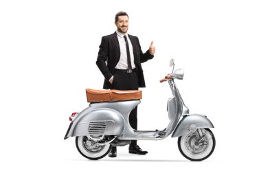 Eski gümüş mobiletiyle poz veren ve beyaz arka planda baş parmak gösteren bir iş adamı.